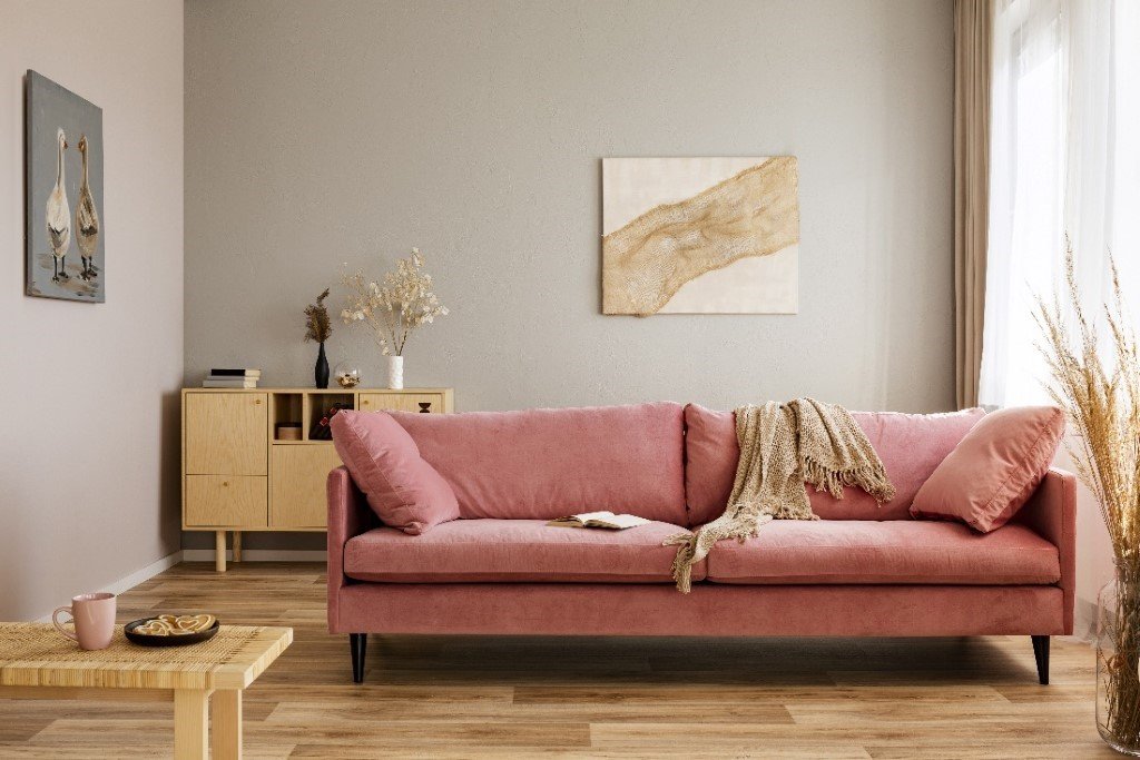 trendy reupholstered pink velvet couch in farm-style room