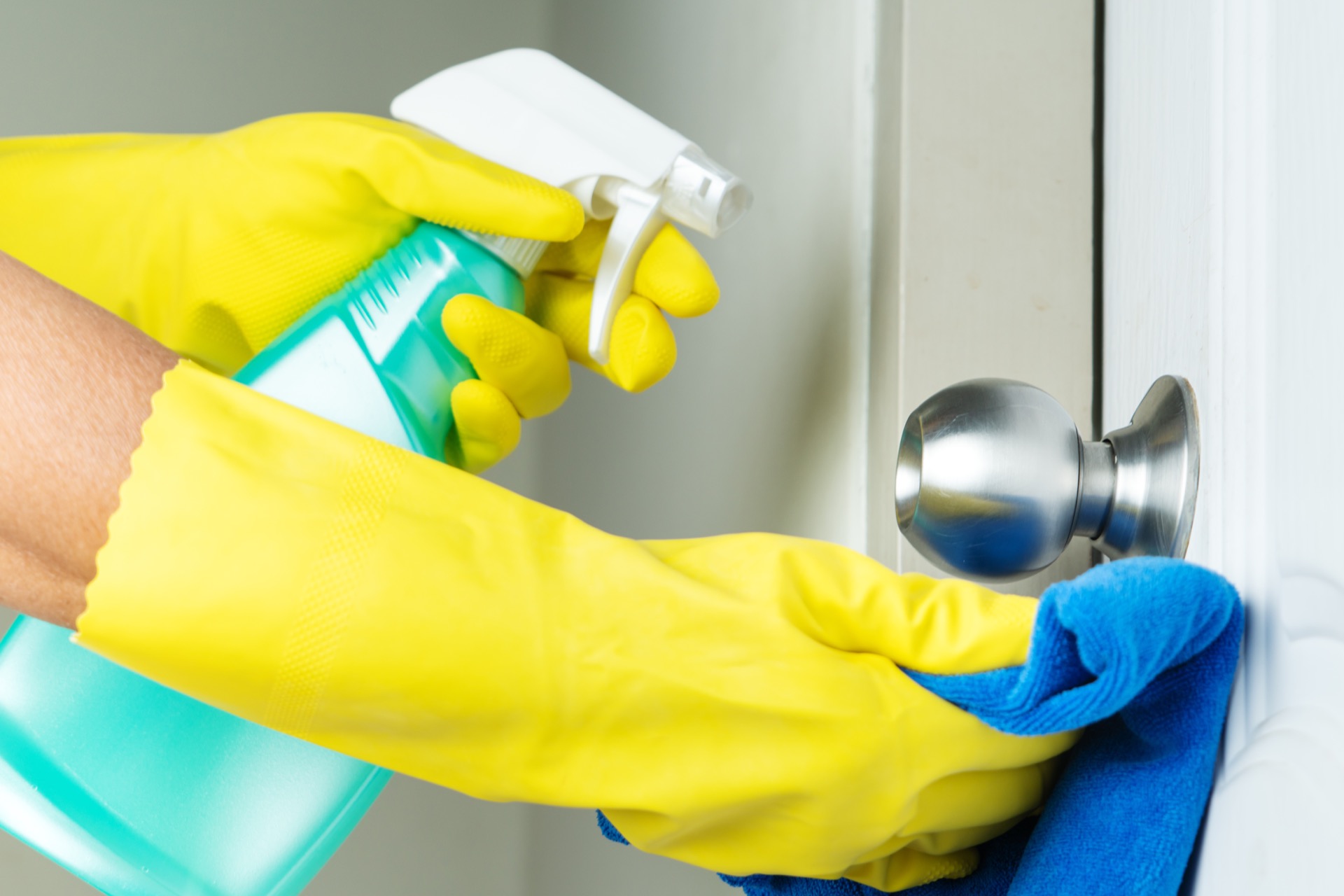 Cleaning door knob with disinfectant for coronavirus
